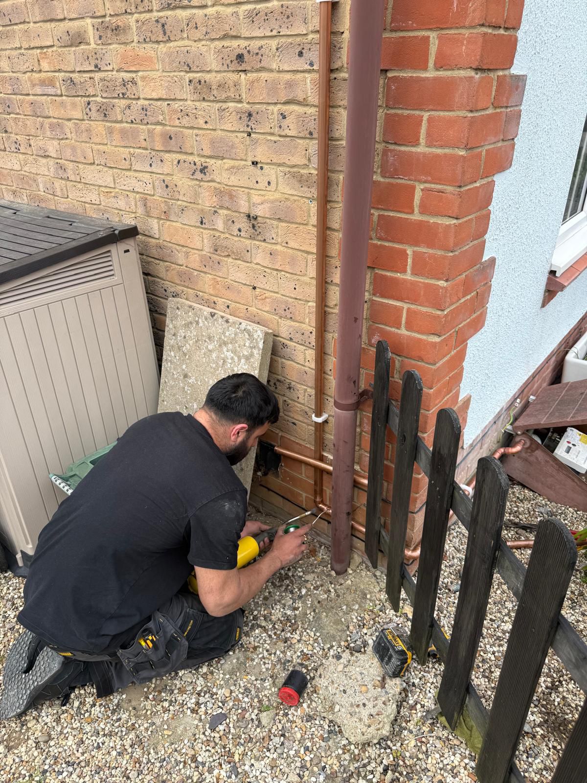 Plumber soldering copper joints externally